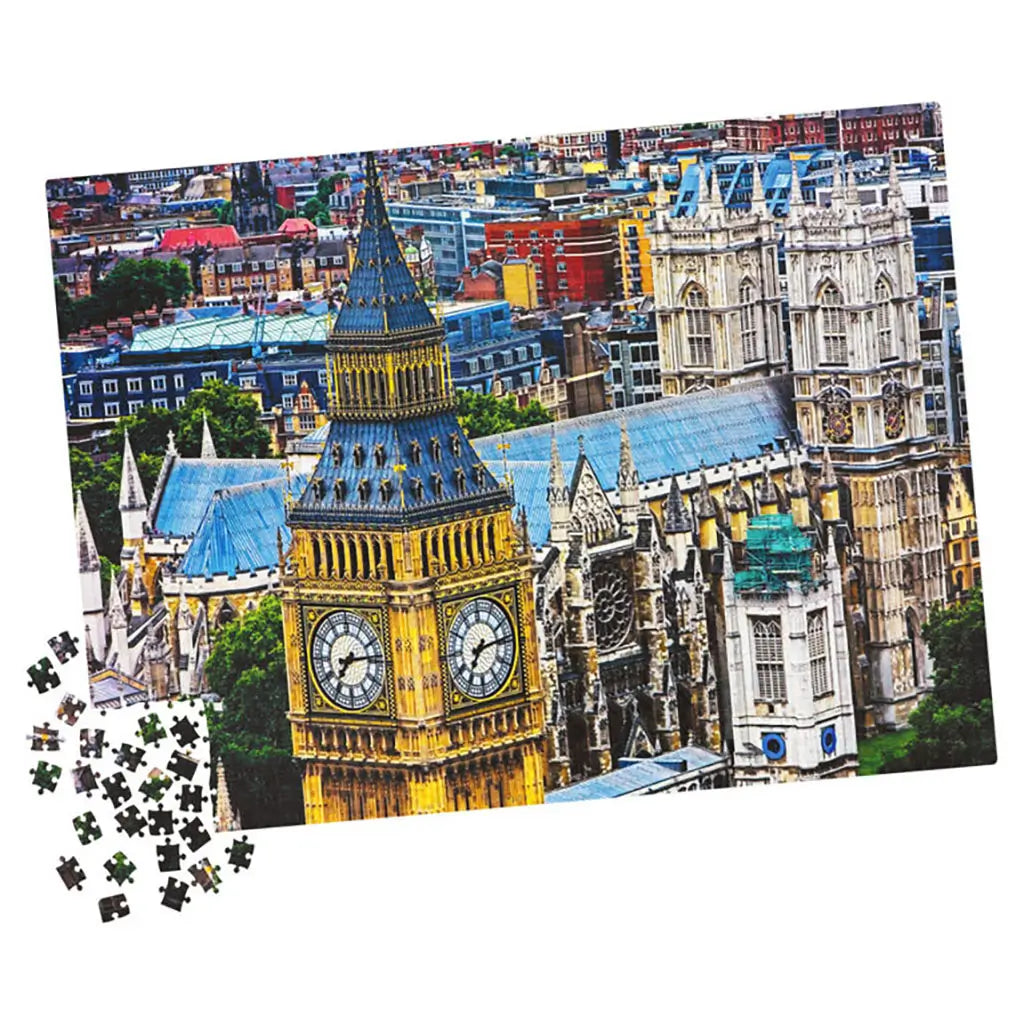 Partially assembled 1000-piece Cardinal jigsaw puzzle of Big Ben and Westminster Abbey, with vibrant golden tower, blue rooftops, and scattered loose pieces on white surface.