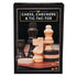 Front view of the Cardinal Classics Chess, Checkers & Tic-Tac-Toe box showing detailed wooden chess and checker pieces in natural and dark brown tones on a polished game board.