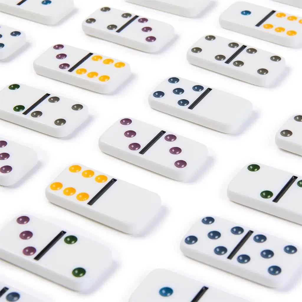 White glossy domino tiles with smooth finish arranged neatly in rows, featuring colored recessed dots in yellow, green, blue, and purple for easy number recognition and vibrant gameplay.