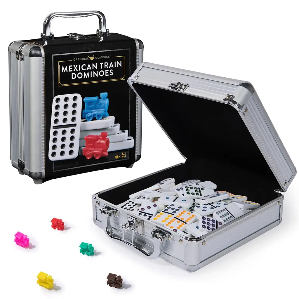 Cardinal Classics Mexican Train Dominoes set in a silver aluminum carrying case with black panel label, white domino tiles and colorful plastic train markers displayed beside the open storage box on a white background.