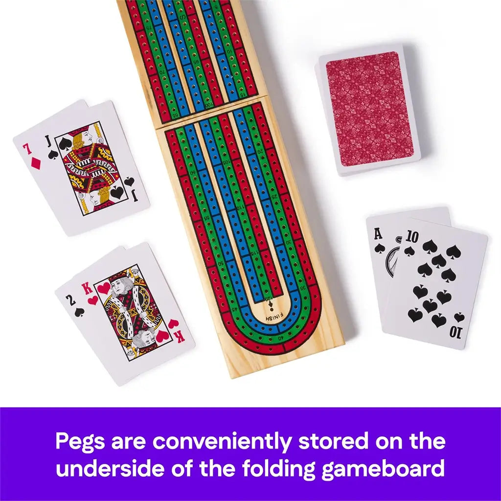 Top view of a folding wooden Cribbage board with red, blue, and green tracks, surrounded by playing cards, highlighting the convenient peg storage built into the underside of the board.