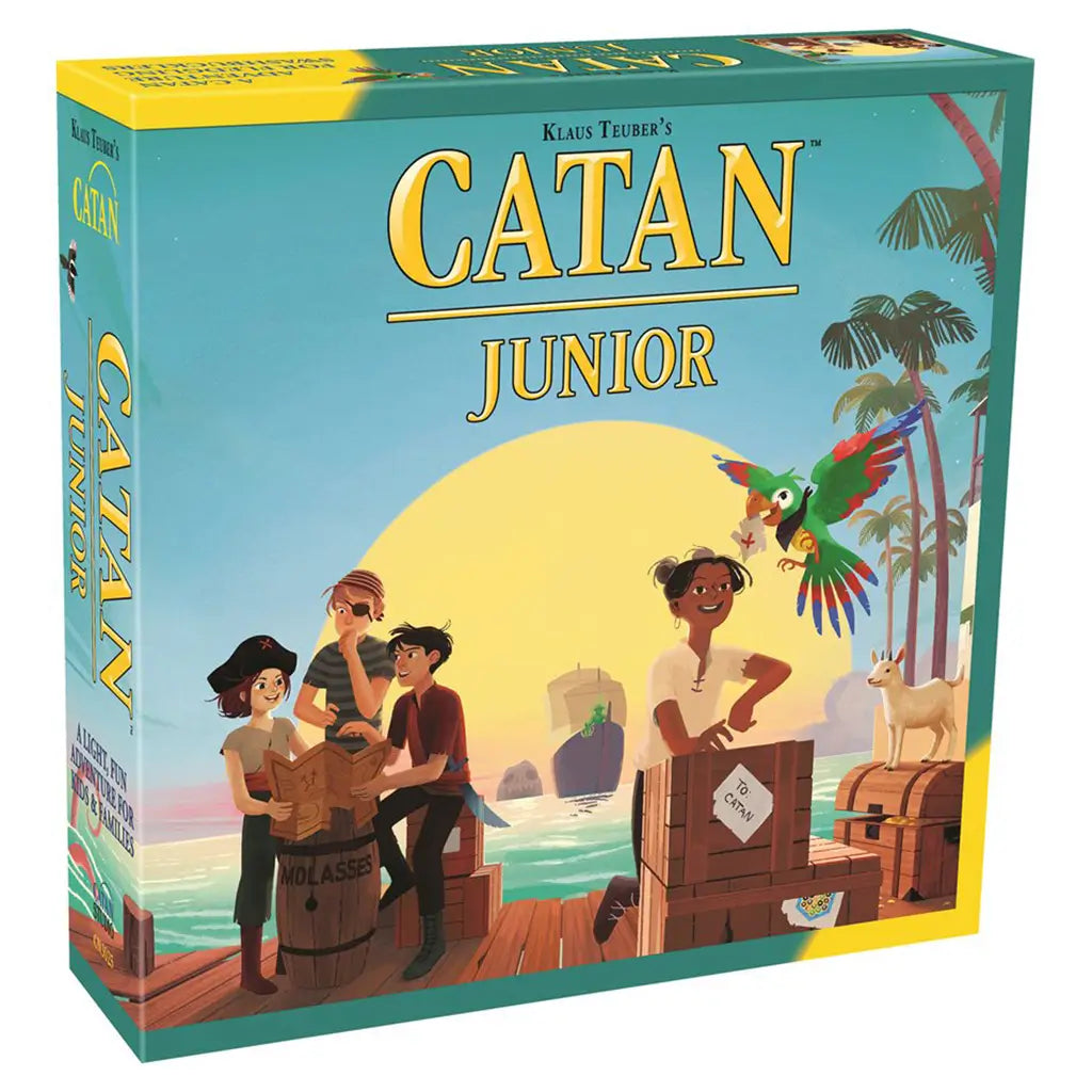 Catan Junior board game box features teal cardboard with large yellow title lettering and illustrated young pirates, a colorful parrot, goat, crates, and tropical island dock.