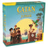 Catan Junior board game box features teal cardboard with large yellow title lettering and illustrated young pirates, a colorful parrot, goat, crates, and tropical island dock.