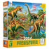 Ceaco 300-piece “Prehistoria” puzzle box showing vivid dinosaurs in a tropical landscape with palm trees, a glowing volcano, and a waterhole surrounded by lush greenery and prehistoric reptiles.
