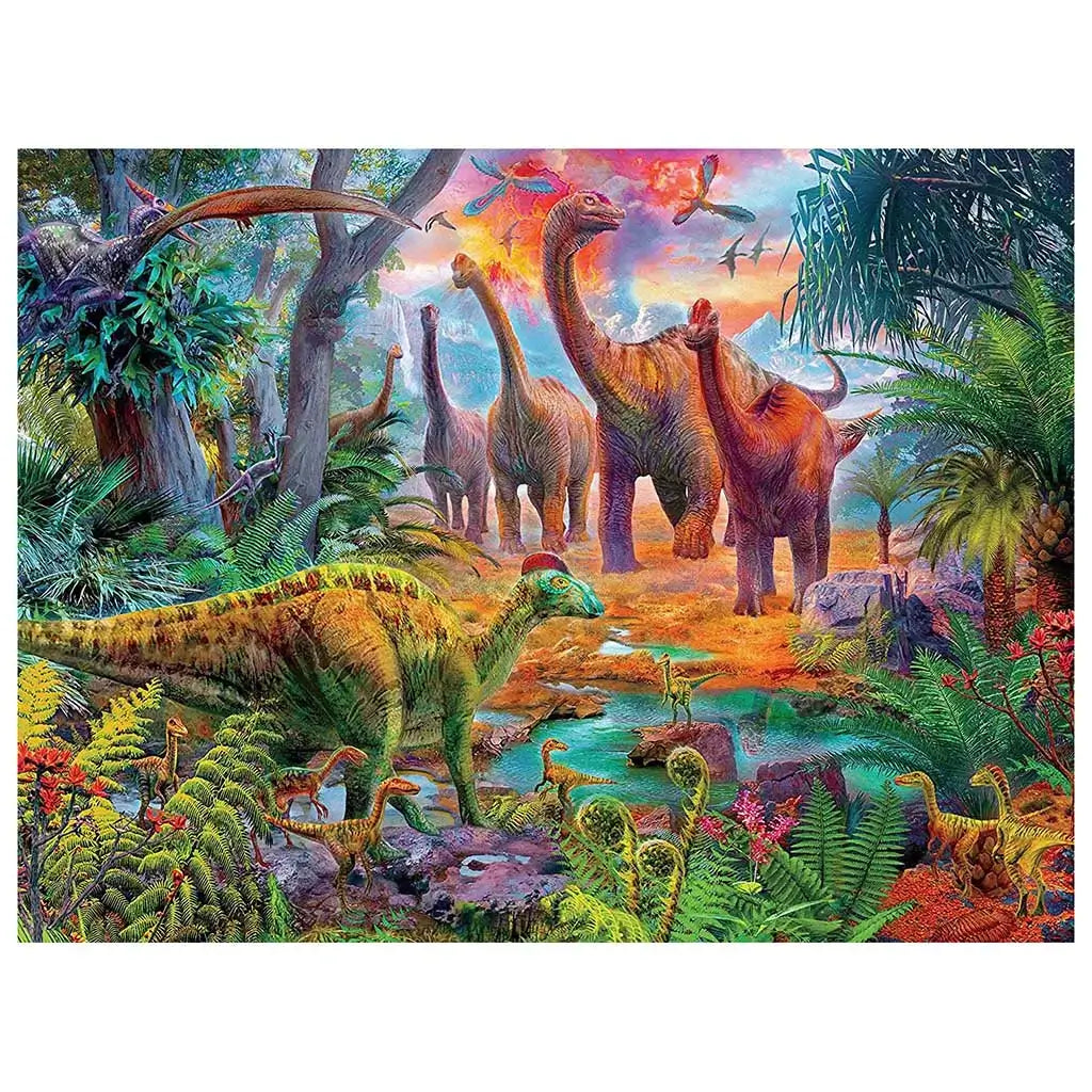 Ceaco Prehistoria puzzle design showing a lush, colorful prehistoric landscape with long-necked dinosaurs, ferns, palm trees, and small dinosaurs near a glowing water stream at sunset.