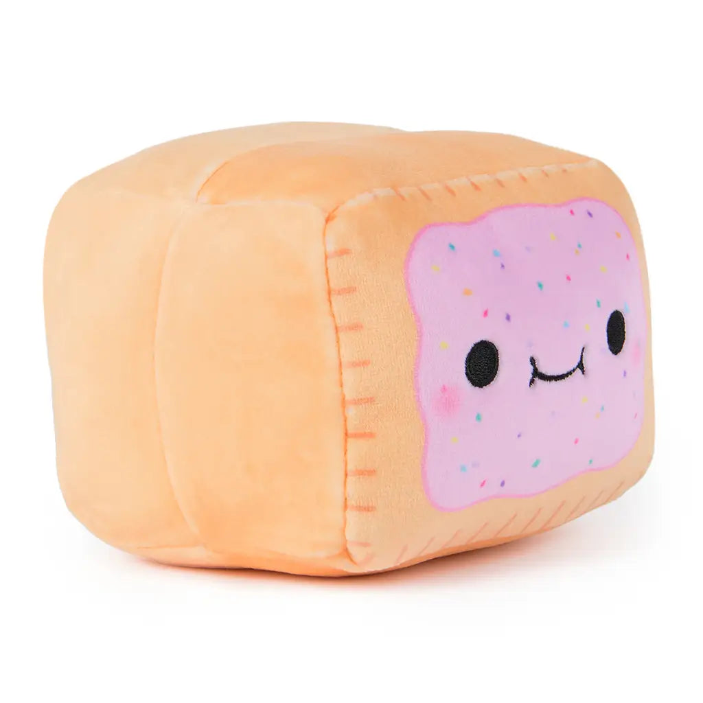 Angled view of Cheeky Chonks Poppin Booty plush toy, showing soft peach sides and happy pink frosted pastry face with colorful sprinkles and blushing cheeks.