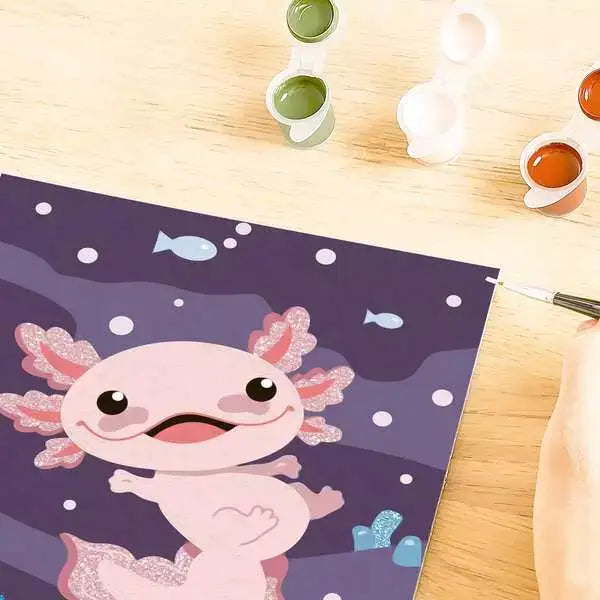 Close-up of partially painted CreArt axolotl artwork showing paint details and small open paint pots on a wooden surface.