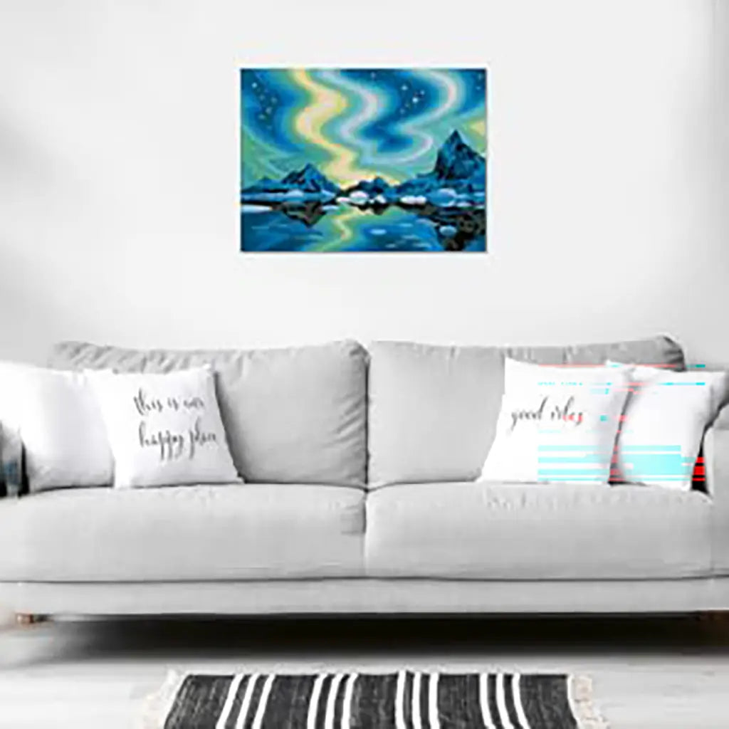 Northern lights painting displayed on a white wall above a gray sofa with decorative pillows, showing how the artwork adds color and atmosphere to the room.