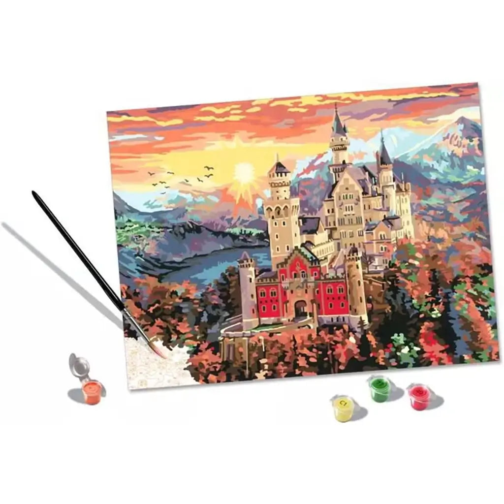 Complete CreArt paint by numbers set with canvas showing castle design, paintbrush, and small numbered acrylic paint pots arranged to finish the detailed artwork.