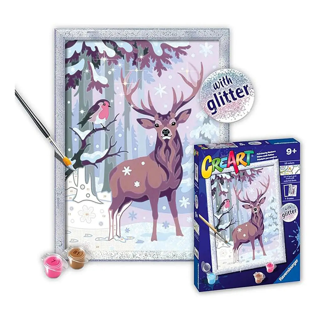 Ravensburger CreArt festive friends glitter painting kit displayed with finished woodland deer scene, included paintbrush, acrylic paint pots, and product packaging box.