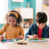 Two children happily painting Peppa Pig CreArt Jr numbered canvases at a table with brushes and included paint pots, encouraging creativity and fun.