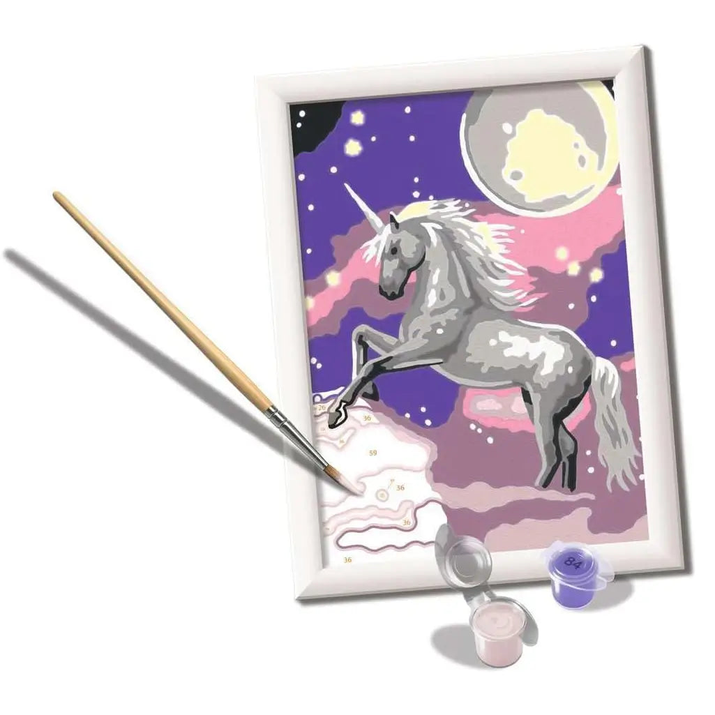 Partially painted unicorn canvas from the CreArt kit, showing paint-by-numbers sections, a brush, and small acrylic paint pots in pastel shades.