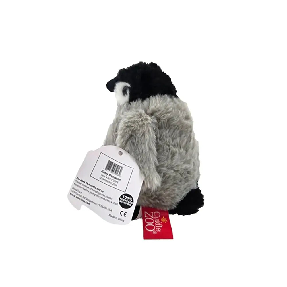 Cuddle Zoo baby penguin plush is seen from a rear angled view with soft grey fur, black head, and attached product tag, emphasizing its cuddly rounded shape against a plain studio background. Designed to highlight its soft materials and child-friendly shape.