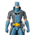 DC Comics Batman action figure in gray and blue armor with a yellow utility belt, black chest emblem, and detailed trench coat design shown in a close-up view.