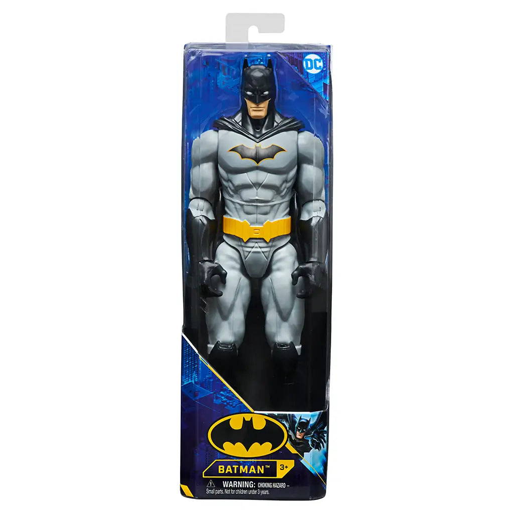 Batman action figure in retail packaging, featuring grey suit, black cape, and yellow utility belt, suitable for ages 3 and up, officially licensed DC toy.