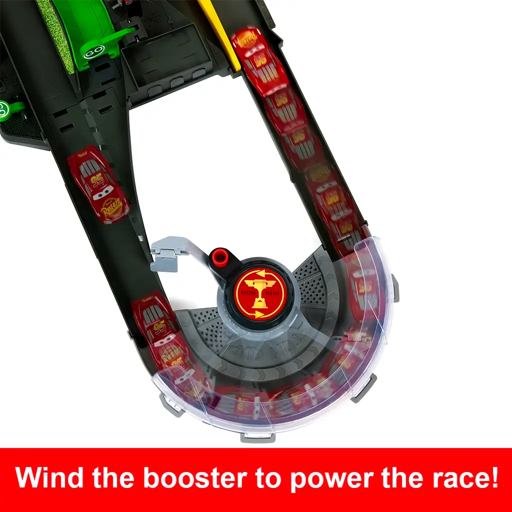 Disney Pixar Cars track close-up featuring a dark gray curved booster section with clear plastic guard, red and yellow Piston Cup emblem, and Lightning McQueen car illustrated in motion to show winding power action.