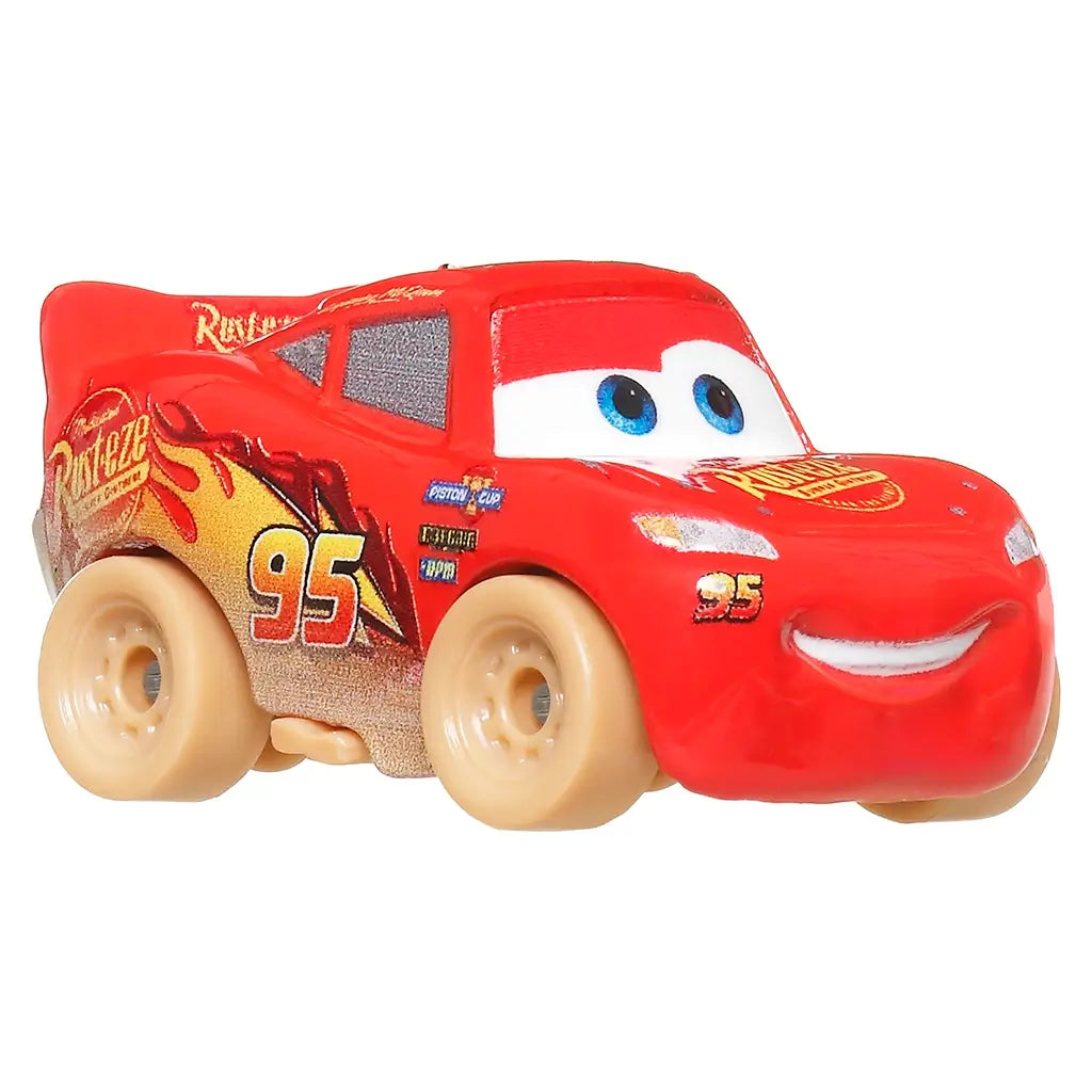 Close-up of Muddy Lightning McQueen mini racer toy from Disney and Pixar Cars with bright red body, blue eyes, number 95, and detailed mud effects for realistic racing fun.