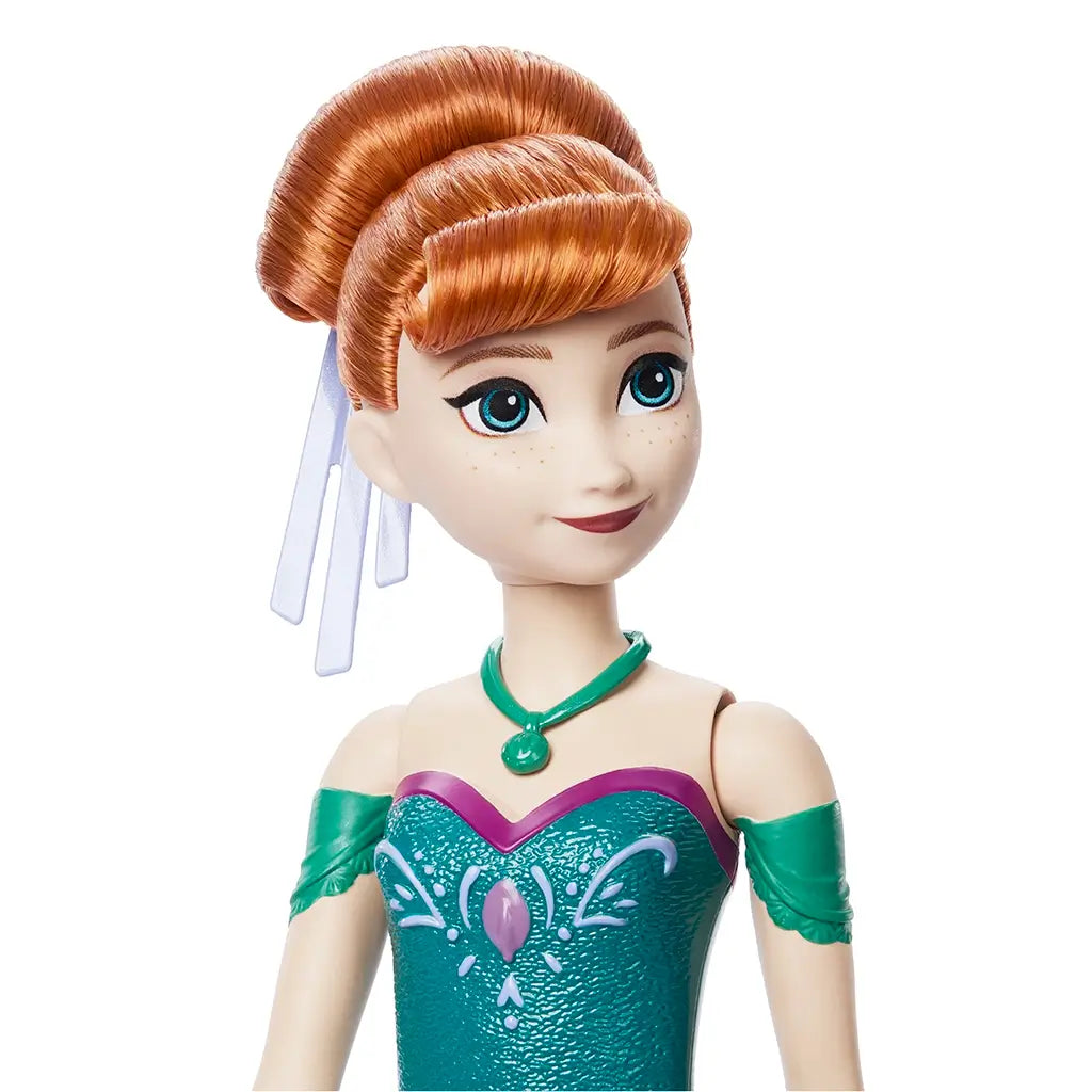 Close-up of Disney Frozen Anna doll with neatly styled red hair in bun, wearing teal and magenta detailed gown and green necklace accessory. Detailed toy description for collectors and children ages 3 and up.
