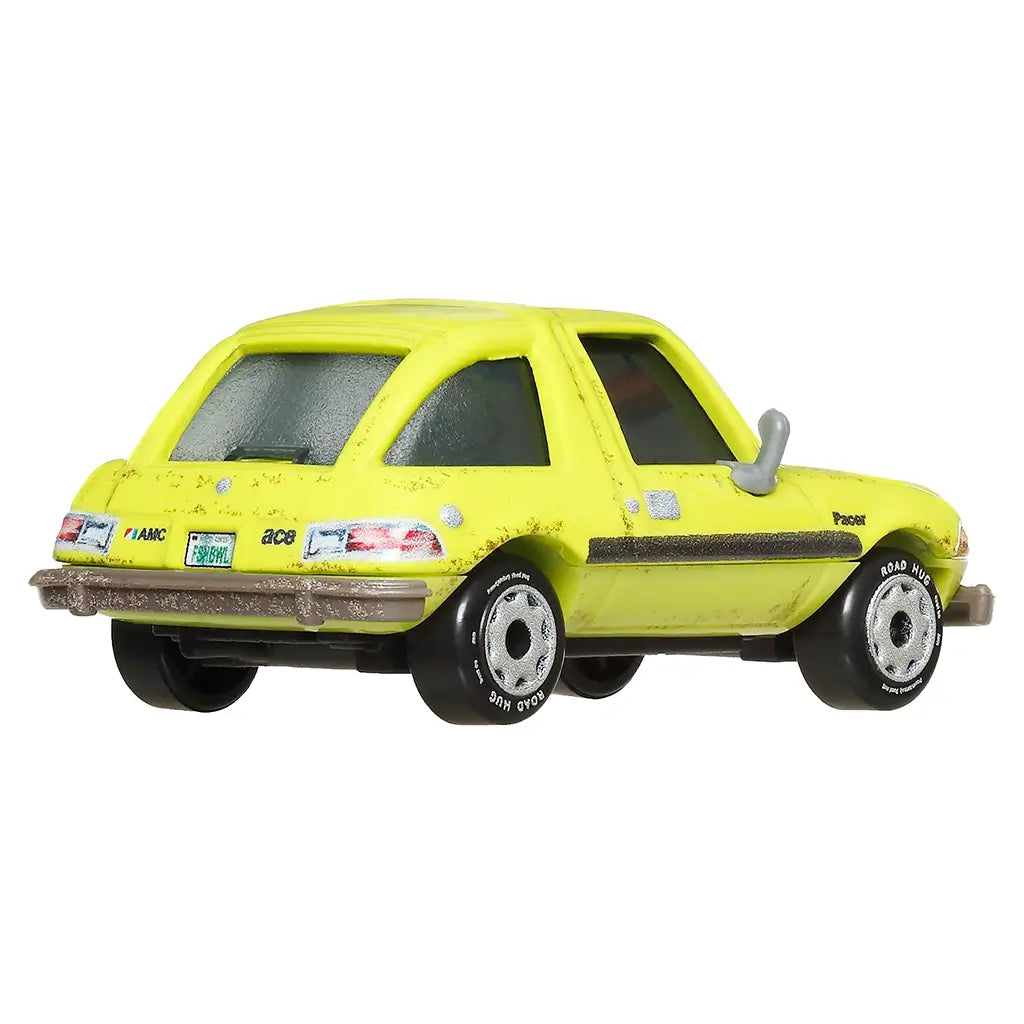 Yellow Pixar Cars Acer diecast toy with AMC logo, green license plate, silver trim, and black wheels, viewed from rear angled perspective with subtle weathering details.