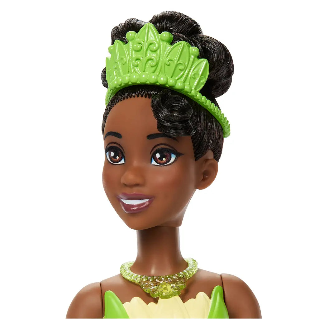 Close-up of Disney Princess Tiana doll wearing green tiara and necklace, showing elegant face sculpt, styled hair, and detailed accessories from her ballgown look.