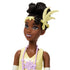 Close-up of Disney Princess Tiana doll wearing yellow bodice with lavender lotus detail, pearl-like necklace, and feather headband, showing elegant face sculpt and hairstyle.