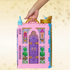 Toy Disney Princess castle with decorative elements - hand holding handle on carry-on-go style fold-up set.