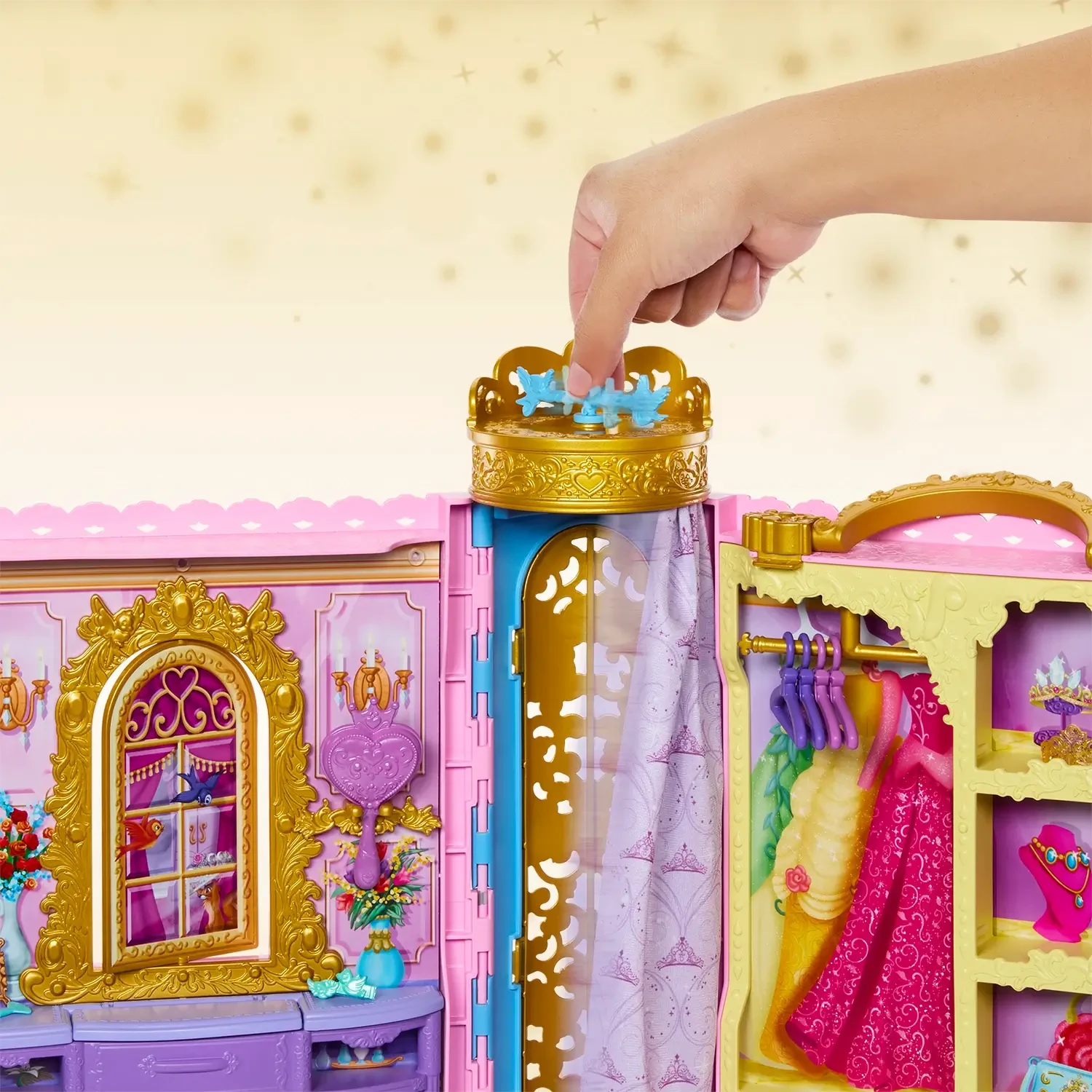 Toy wardrobe with gold and pink accents, featuring a hand interacting with it.