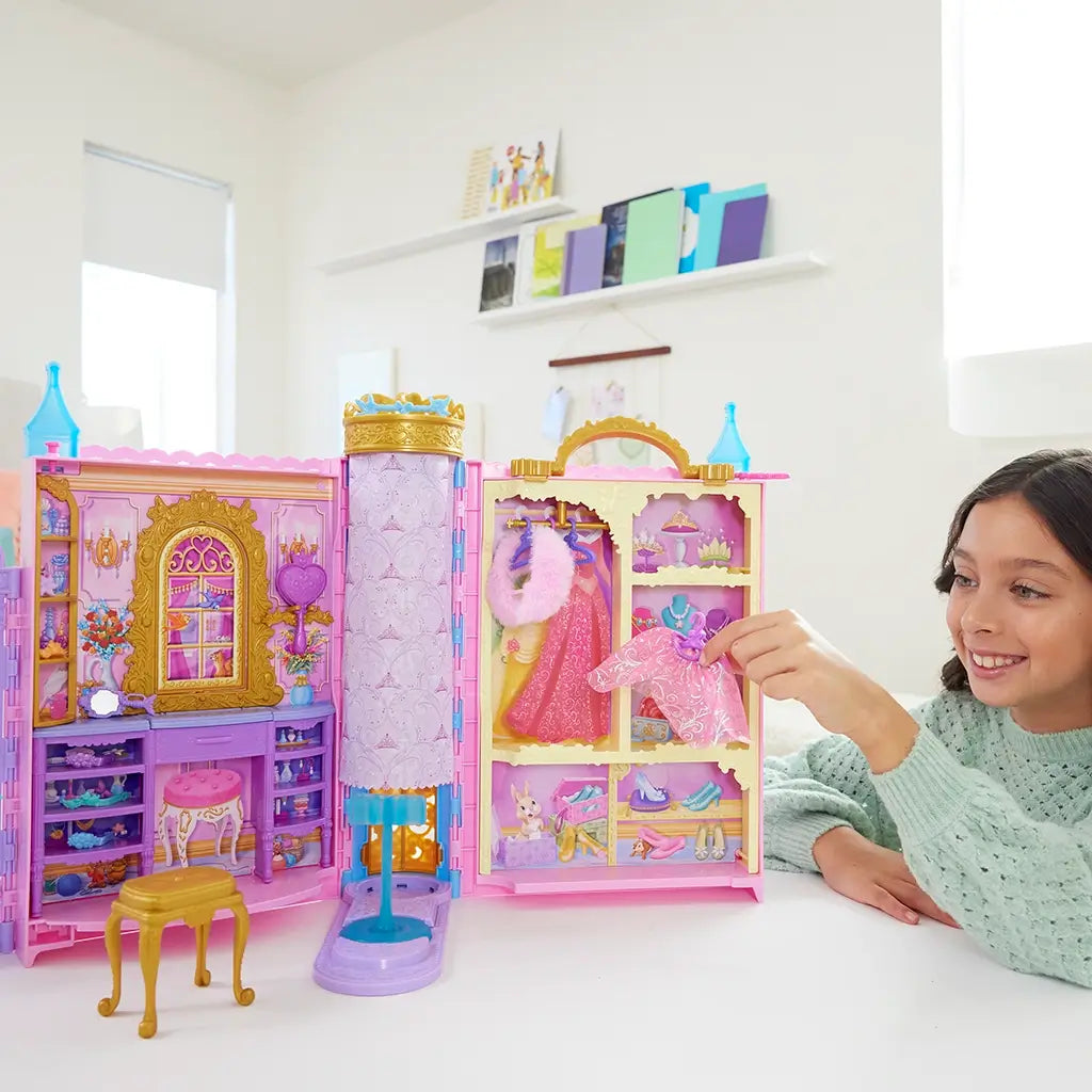 Girl playing with a Disney Princess dollhouse in a bright room