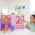Girl playing with a Disney Princess dollhouse in a bright room
