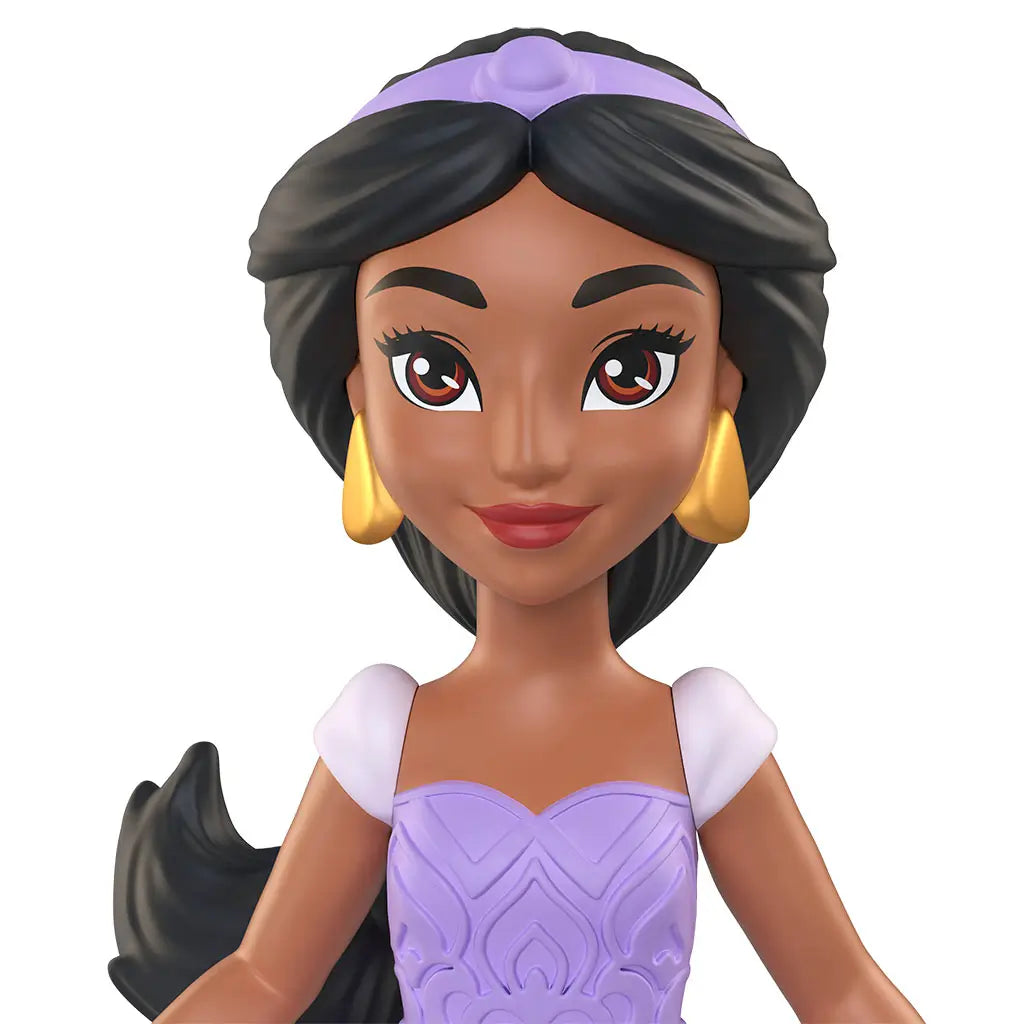 Disney Princess Jasmine doll close up showing warm brown skin tone, large painted brown eyes, red lips, black hair styled back with a lavender headband, and gold earrings against a white backdrop.