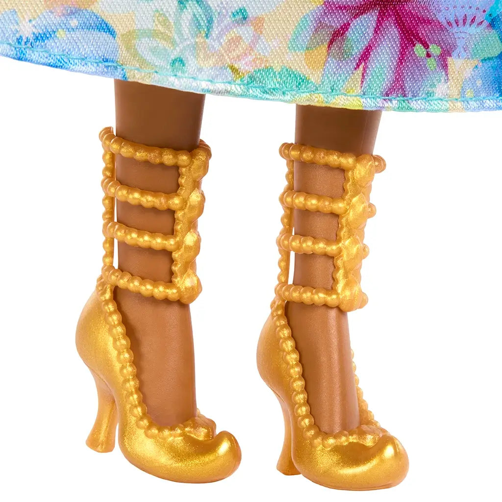 Close-up of Disney Princess Jasmine doll’s detailed golden high-heeled shoes with beaded strap design under floral skirt.