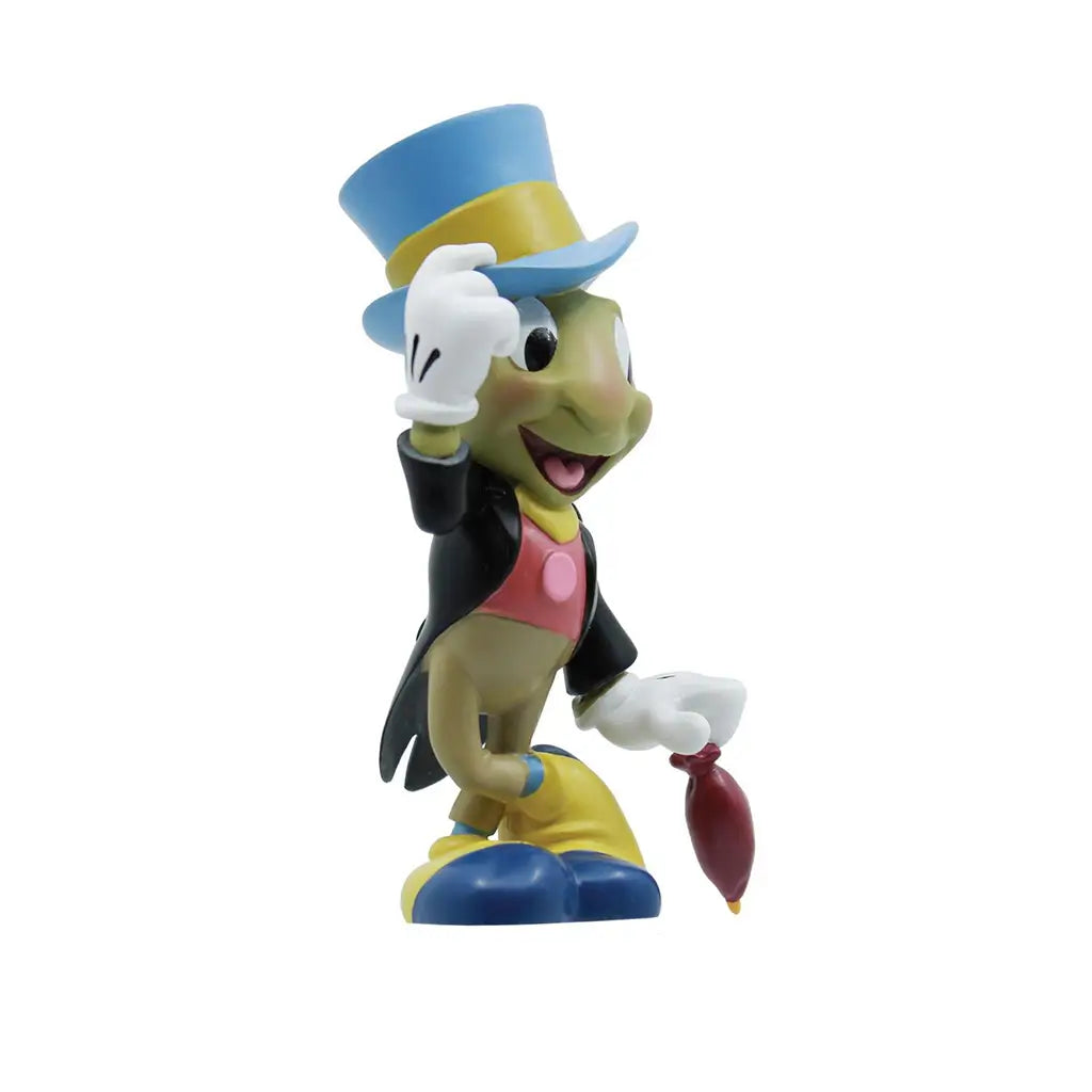 Angled side view of Jiminy Cricket in colorful formal outfit tipping his hat, holding a red umbrella; 3.5-inch Disney Showcase collectible for Pinocchio 85th anniversary.