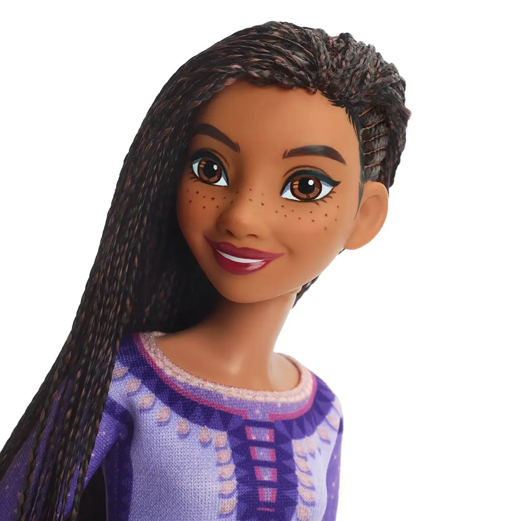 Close-up of Disney Wish Singing Asha of Rosas doll's face showing her detailed features, including long lashes, freckles, and long braided hair, promoting lifelike design.