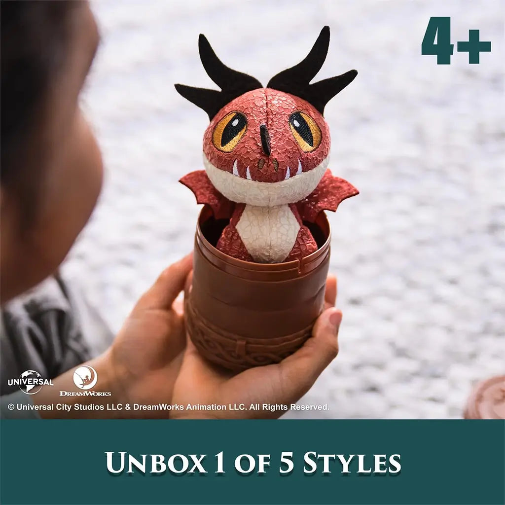 How to Train Your Dragon red mini plush in soft textured fabric with black horns and cream belly, popping out of a brown totem capsule for surprise unboxing play.