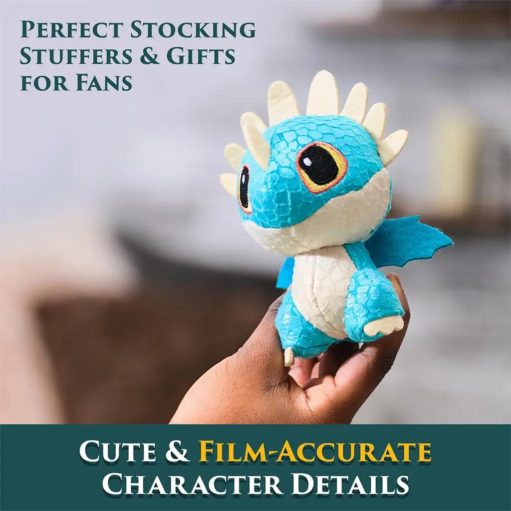 How to Train Your Dragon blue mini plush in soft textured fabric with cream belly, small wings, and embroidered eyes, held in hand to show film-accurate character details indoors.