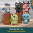 Dragons of Berk mini plush characters in blue, black, red, and green textured fabric with rounded shapes and tiny wings, arranged on brown totem stands near a bright window display.