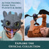 DreamWorks How to Train Your Dragon action figures and plush toys in gray and black molded plastic and soft fabric, featuring Toothless mask and dragon figure displayed against a blue backdrop.