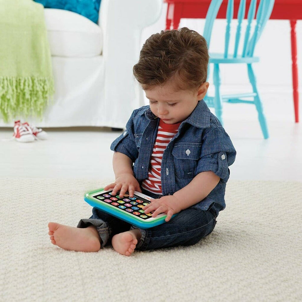 Baby boy playing with the Smart Tablet while sitting 