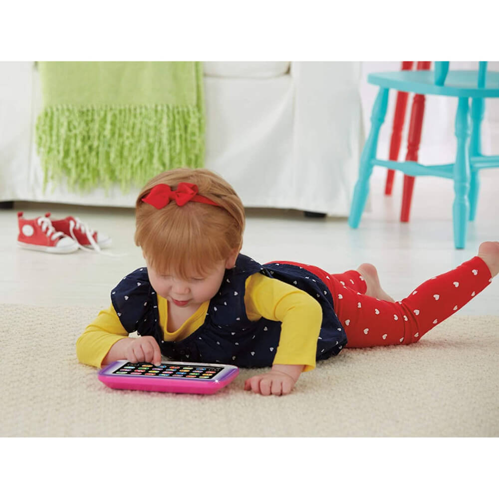 Girl lying on the her belly playing with the Pink Smart Stagest Tablet toy.
