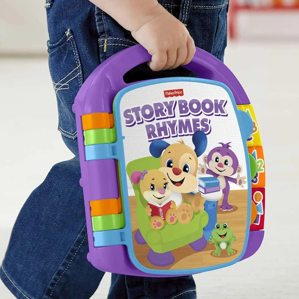 A toddler carries the Fisher-Price Storybook Rhymes toy by its purple handle, showing bright side buttons and cheerful cover art designed for portable early-learning play.