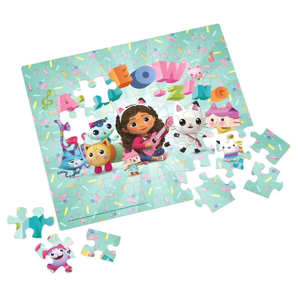 Partially completed Gabby’s Dollhouse puzzle with Gabby and cat characters surrounded by sprinkles, featuring the colorful “A-Meow-Zing” message and several loose puzzle pieces.