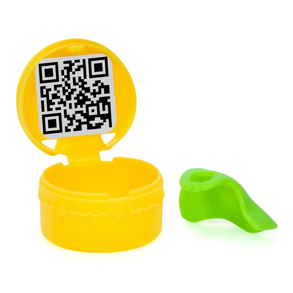 Gabby’s Dollhouse surprise QR code accessory in bright yellow smooth plastic round container with hinged lid and small curved green slide piece, designed for dollhouse delivery role-play scenes.