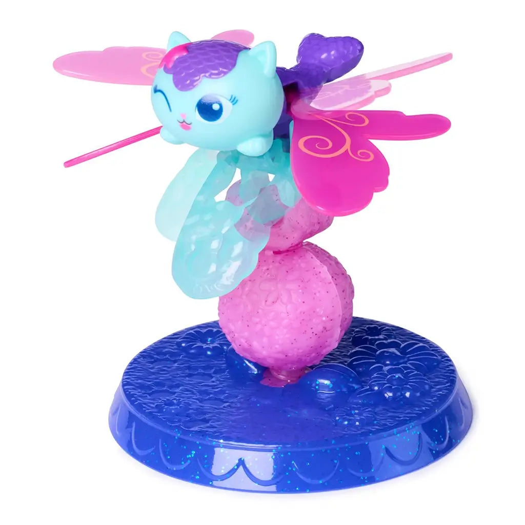 Gabby’s Dollhouse MerCat fairy figure in pastel blue, pink, and purple glossy plastic with winged shape and rounded base stand, designed for imaginative play, displayed on a white background.
