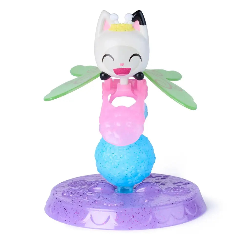 Gabby’s Dollhouse Pandy Paws fairy figure in white, pink, blue, and green glossy plastic with winged design and textured base stand, created for imaginative play, displayed on a white background.