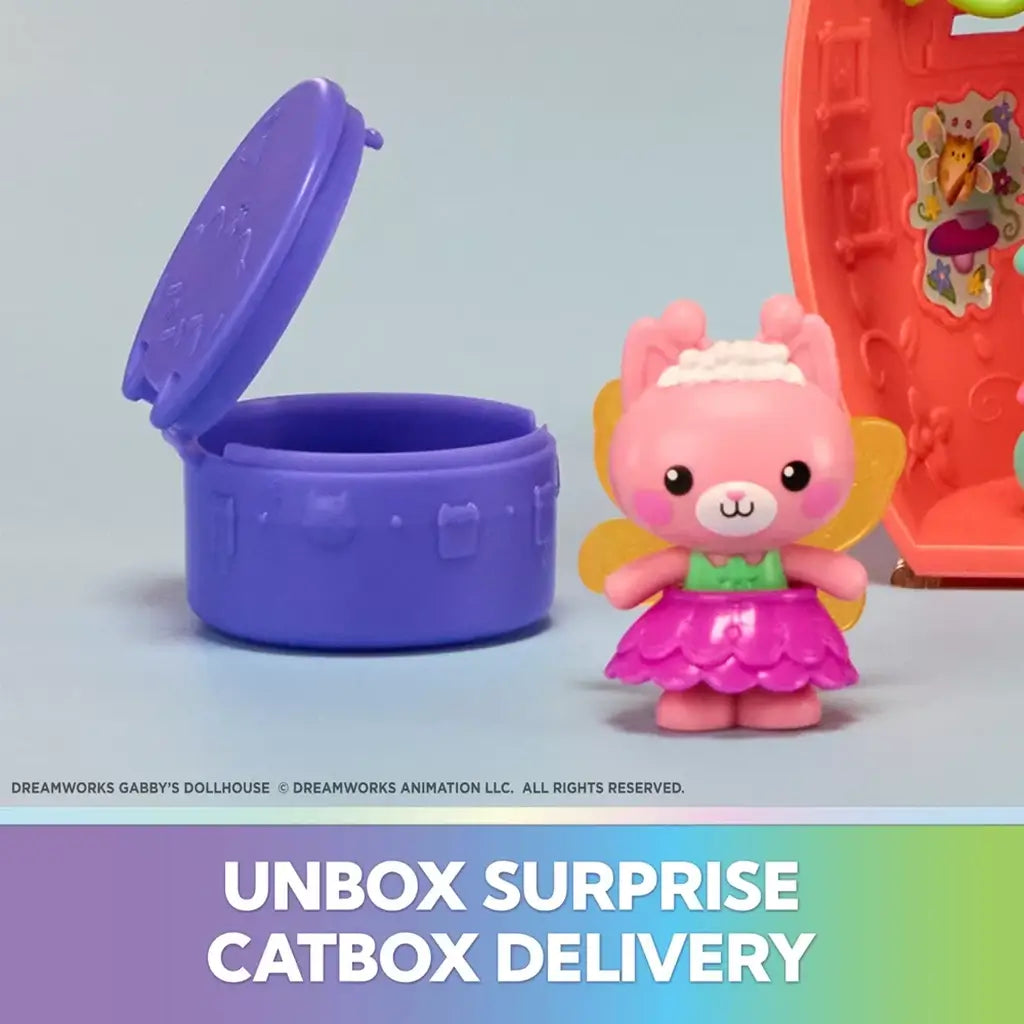 Gabby's Dollhouse Catbox Delivery set in bright pink and purple plastic featuring a small winged cat figure beside an open round container, displayed against a soft blue background.