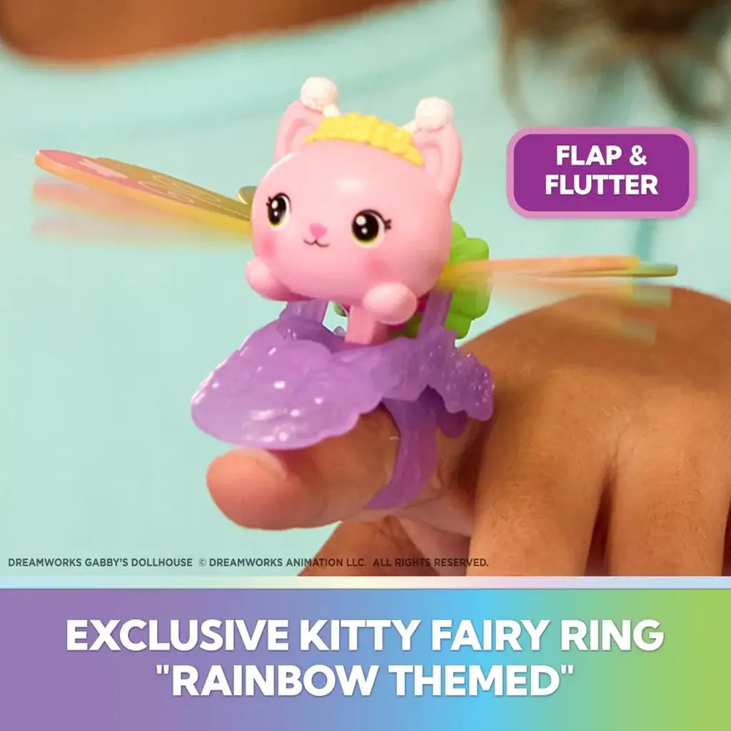 Gabby's Dollhouse kitty fairy ring in pink and purple plastic worn on a finger, featuring a winged cat with translucent yellow wings that flap for interactive play.