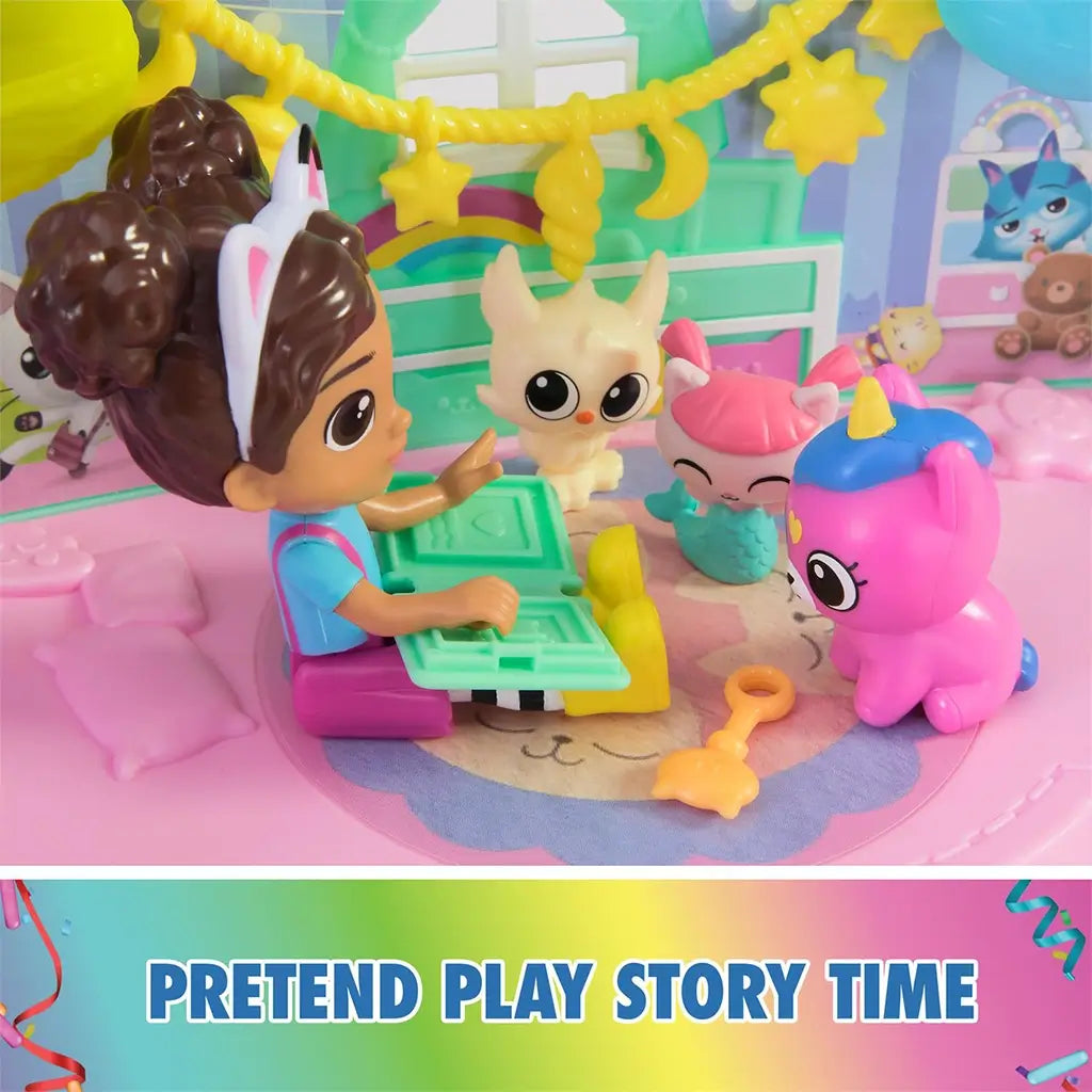 DreamWorks Gabby's Dollhouse Kitty Care Ear Purrfect Playroom pretend story time scene with pastel plastic figures, rainbow decor, nursery furniture and small accessories on play mat.