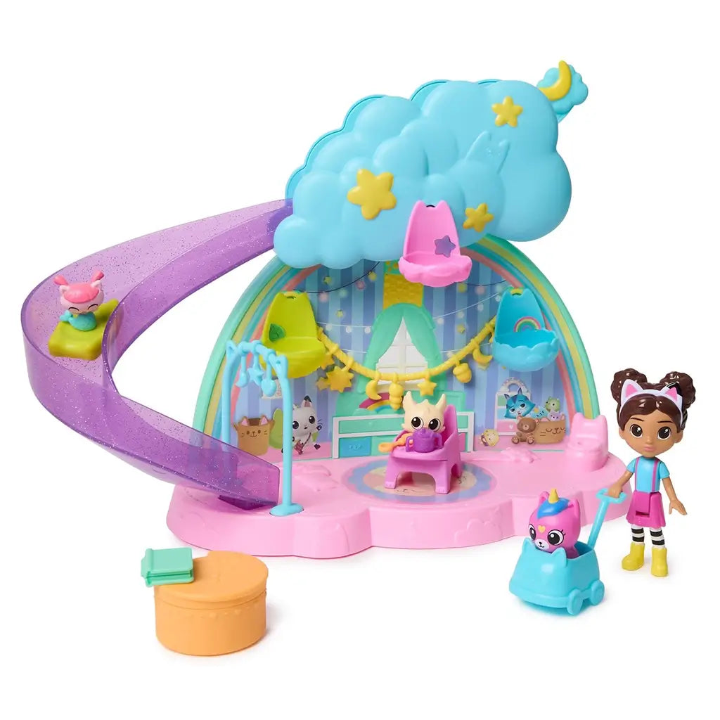 DreamWorks Gabby's Dollhouse Kitty Care Ear Purrfect Playroom in blue and pink molded plastic with glittery purple slide, rainbow arch and nursery furniture displayed on a white background.
