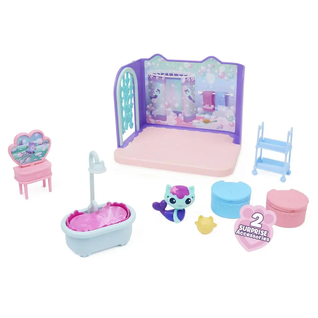 Gabby’s Dollhouse toy set pieces in pastel plastic with smooth textures and rounded shapes, including tub, vanity, figure, and accessories, arranged neatly on a white background.