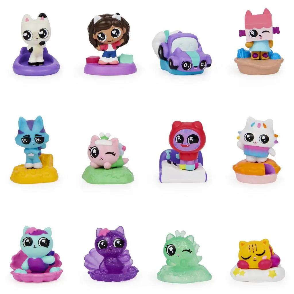Colorful plastic Gabby’s Dollhouse mini figures, including cats, animals, and vehicles, arranged in three rows on a white background, showcasing collectible toy designs with large expressive eyes.